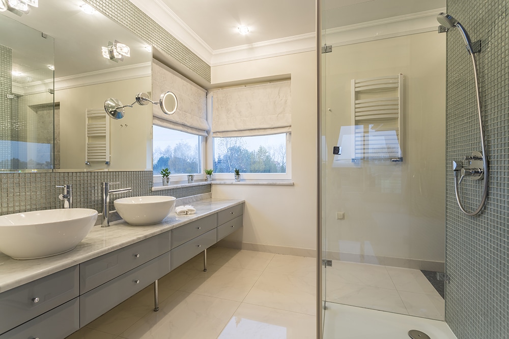 Spacious white bathroom with glass door shower and two sinks