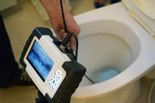 A plumber using a snake camera to investigate a clogged toilet in Eldersburg, Maryland.