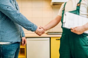 plumber shakes hands with a happy customer