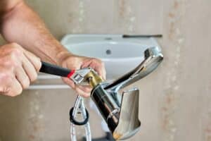 plumber installs a new sink faucet