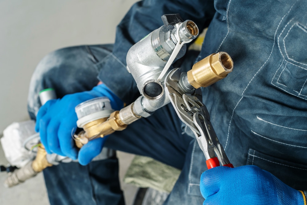 plumber uses wrench on pipe work