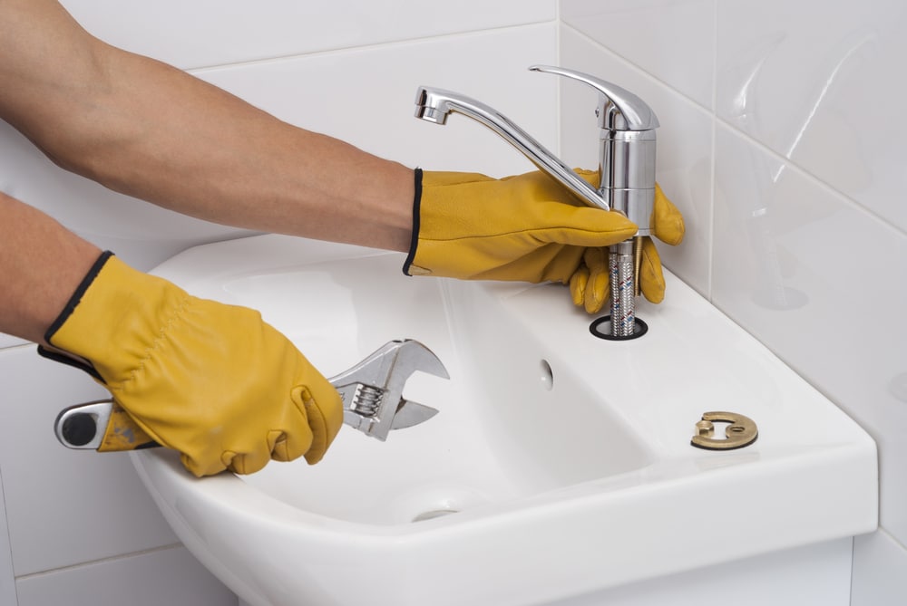 plumber installs a faucet