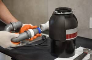 plumber installs garbage disposal