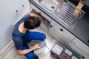 plumber declogs a drain