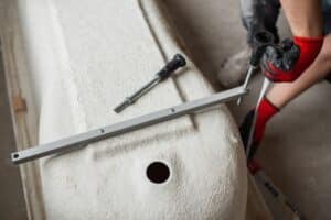 plumber installs a bath tub