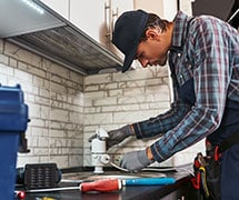 plumber fixes a faucet