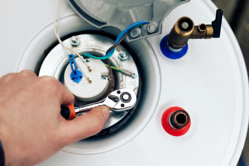 the worker has finished servicing the boiler and tightens the last nuts