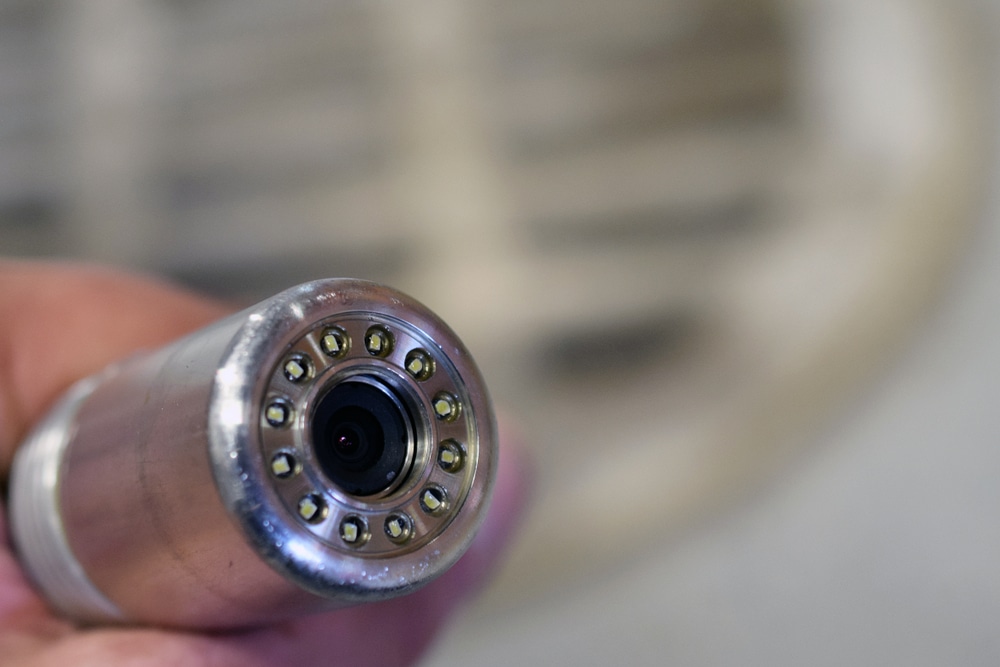 Sewer camera head close up. Sewer manhole on background. Shallow depth of field.