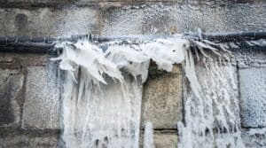Frozen water after burst from a pipe at the winter.