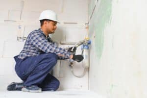plumber installing water equipment - meter, filter and pressure reducer