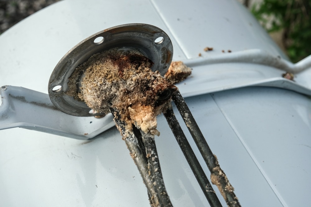 Electric water heater heating element, worn and covered with limescale.