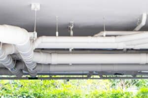 Structure plastic pipes under building or apartment. Plumbing rough-in or electrical conduit in commercial building with pvc pipe in construction site of apartment.