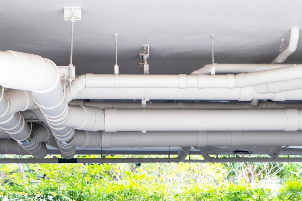 Structure plastic pipes under building or apartment. Plumbing rough-in or electrical conduit in commercial building with pvc pipe in construction site of apartment.